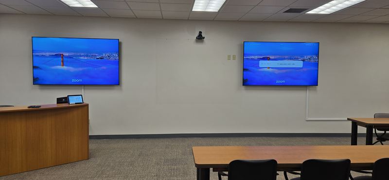 Dual-display conference room — Two displays on a single wall so far-end video and shared content each get a full screen.