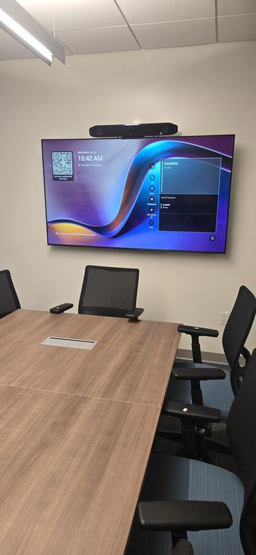 Conference room — Display with video bar above, control on the table surface.